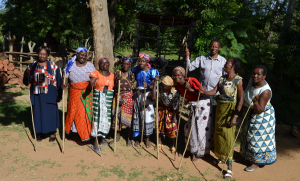 women-each-holding-a-measuring-stick-for-their-cleome-plots-prepare-to-sing-after-sowing-seed